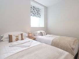 A bedroom with two beds and a window at The Gatehouse 