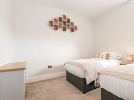 A bedroom with two beds and a dresser at The Gatehouse