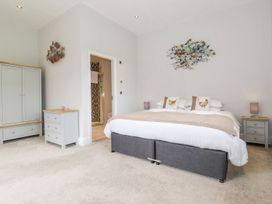 A bedroom with a bed, wardrobe, and nightstands at The Gatehouse 