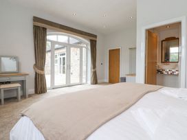 A bedroom with a bed and glass doors at The Gatehouse