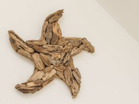 A star-shaped wall decoration made of wooden pieces on a white wall at Launcher's Cottage in Scarborough