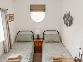 A bedroom with two beds and a window at Launcher's Cottage in Scarborough