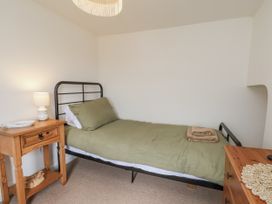 A bedroom with a bed and side table at Launcher's Cottage Scarborough