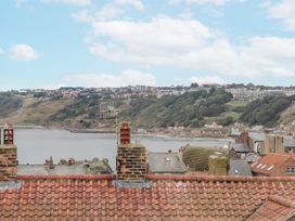 A view of rooftops and hills near the water at Launcher's Cottage in Scarborough