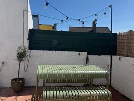 An outdoor seating area with a green table and plant at Launcher's Cottage in Scarborough