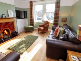 A living room with a fireplace and television at Dinguardi in Seahouses