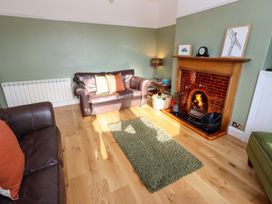 A living room with a fireplace and sofa at Dinguardi in Seahouses