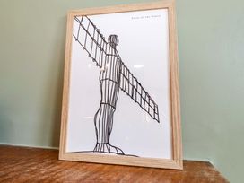 A framed art piece of the Angel of the North at Dinguardi in Seahouses