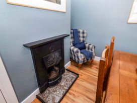 A dining room with a fireplace and an armchair at Dinguardi in Seahouses