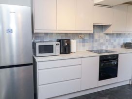 A kitchen with appliances and cabinets at Dinguardi in Seahouses