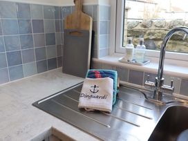 A kitchen sink with a towel and cutting board at Dinguardi in Seahouses