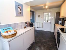 A kitchen with cabinets and appliances at Dinguardi in Seahouses