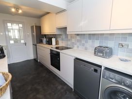 A kitchen with appliances and cabinets at Dinguardi in Seahouses
