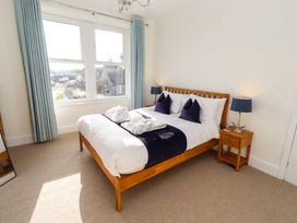A bedroom with a bed and bedside tables at Dinguardi in Seahouses