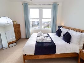 A bedroom with a bed and mirror at Dinguardi in Seahouses