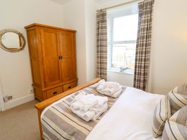 A bedroom with a bed and wardrobe at Dinguardi in Seahouses