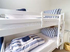 A bunk bed with striped bedding in a bedroom at Dinguardi in Seahouses