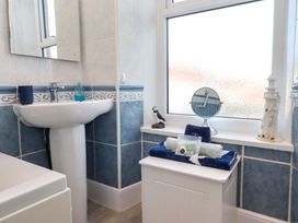 A bathroom with a sink and mirror at Dinguardi in Seahouses
