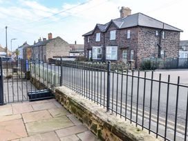 A view of houses and a street from a fenced area at Dinguardi in Seahouses