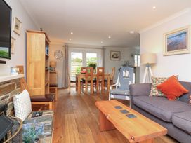 A living room with a sofa and dining area at Eydon in Salcombe