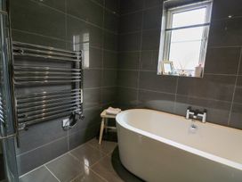A bathroom with a freestanding bathtub and heated towel rail at Eydon in Salcombe