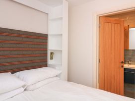 A bedroom with a bed and an open door to a bathroom at Eydon in Salcombe