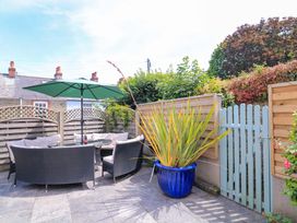A garden with a seating area and a blue flower pot at Eydon in Salcombe