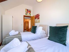 A bedroom with two single beds and a wardrobe at 1 Eastdon Cottages in Exeter