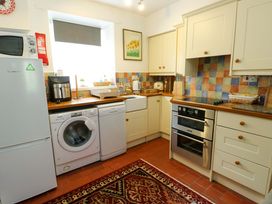 A kitchen with appliances and countertops at Riverbank Cottage Beddgelert