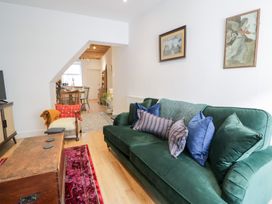 A living room with a green sofa and a coffee table at Derwen House in Llangollen