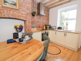 A kitchen with a round table and chairs at Derwen House in Llangollen