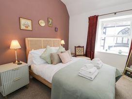 A bedroom with a bed and window at Derwen House in Llangollen