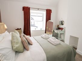 A bedroom with a bed and a dressing table at Derwen House, Llangollen