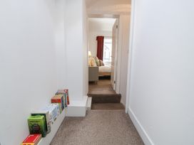 A hallway with books on a shelf and a view of a bedroom at Derwen House Llangollen