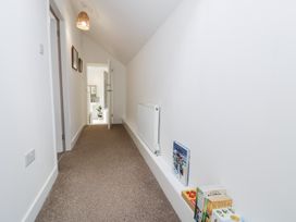 A hallway with books on the floor at Derwen House in Llangollen