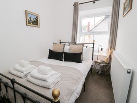 A bedroom with a bed and side table at Derwen House in Llangollen