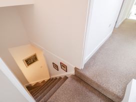 A staircase with paintings on the wall at Derwen House in Llangollen