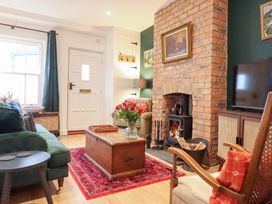 A living room with a fireplace and sofa at Derwen House in Llangollen