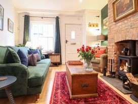 A living room with a sofa and fireplace at Derwen House in Llangollen