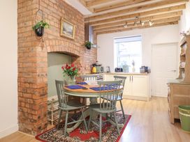 A kitchen with dining table and brick wall at Derwen House Llangollen