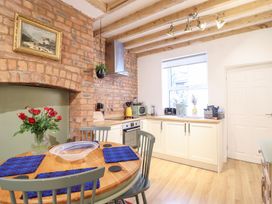A kitchen with a dining table and appliances at Derwen House in Llangollen