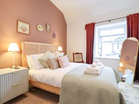 A bedroom with a bed and bedside table at Derwen House in Llangollen