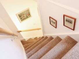A staircase with paintings on the wall at Derwen House in Llangollen