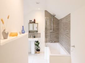 A bathroom with a bathtub and sink at Derwen House in Llangollen