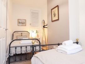 A bedroom with two beds and a lamp at Derwen House in Llangollen