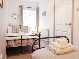 A bedroom with two beds and a window at Derwen House in Llangollen