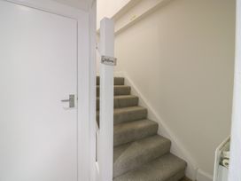 A hallway with stairs and a door at 21A High Street, Jedburgh