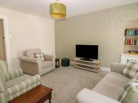 A living room with a television and seating at 21A High Street, Jedburgh