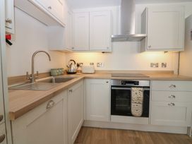 A kitchen with a sink, stove, and cabinets at 21A High Street, Jedburgh