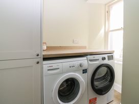 A laundry room with a washing machine and dryer at 21A High Street in Jedburgh